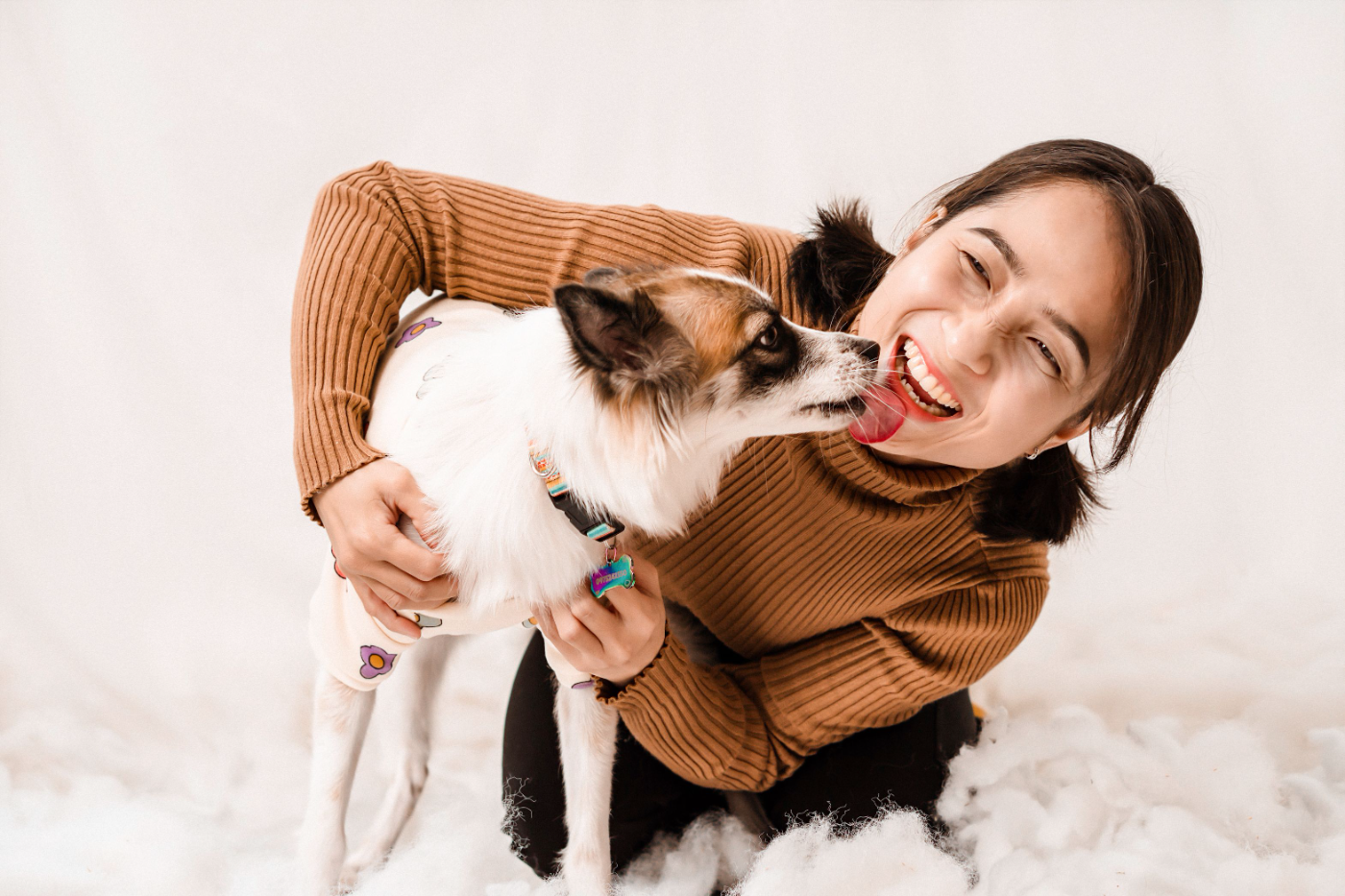 A volunteer getting a kiss from a dog